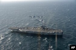 美日战机飞越美国海军里根号航空母舰。（2017年11月10日）