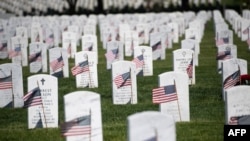 U.S. flags are seen at grave sites at Arlington National Cemetery in Arlington, Virginia, May 24, 2019, ahead of Memorial Day weekend.