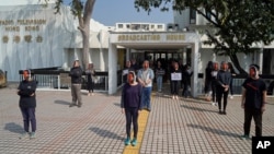 香港電台的員工頭戴新聞主播利君雅的面罩在廣播大樓外進行靜默抗議。 （2021年1月28日）