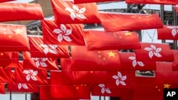 ທຸງ​ຊາດ ຈີນ ແລະ ຮົງ​ກົງ ໃນ​ຂະ​ນະ​ທີ່​ເມືອງ​ດັ່ງ​ກ່າວ​ສະ​ຫຼອງວັນ​ຊາດ ຈີນ ໃນ​ໂຮງ​ກົງ, 1 ຕຸ​ລາ 2023.(AP Photo/Chan Long Hei, File)