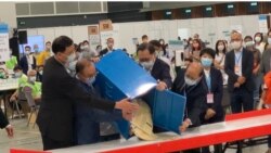 香港選管會主席馮驊（前排右二）與政制及內地事務局局長曾國衛（左二）9月19日晚在會展點票中心，監督選委會選舉首個投票箱的開票過程 (美國之音湯惠芸)