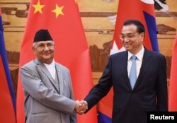 中國國務院總理李克強與來訪的尼泊爾總理奧利在人民大會堂簽字儀式上握手(2018年6月21日)