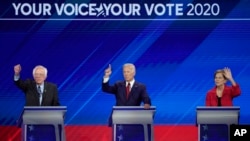 From left, Democratic presidential candidates Sen. Bernie Sanders, I-Vt., former Vice President Joe Biden and Sen. Elizabeth Warren, D-Mass. raise their hands to answer a question Sept. 12, 2019, during a Democratic presidential primary.