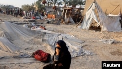 ແມ່​ຍິງ​ຄົນ​ນຶ່ງ​ນັ່ງ​ເສຍ​ໃຈ ຫຼັງ​ຈາກ​ການ​ໂຈມ​ຕີ​ຂອງ​ອິ​ສ​ຣາ​ແອ​ລ ໃນ​ເມື​ອງ ຄ​ານ ຢູ​ນິ​ສ.