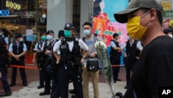 2021 年 7 月 2 日，一名男子手持鮮花悼念在香港刺傷一名警察的襲擊者的死亡。