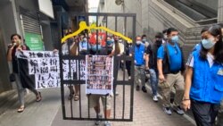 社民連成員曾健成手持道具”鐵牢籠”，貼上被當局以國安法”煽動顛覆國家政權罪”控告的47名民主派初選人士海報，抗議當局囚禁民意代表 (美國之音湯惠芸)