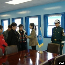 游客在非军事区停战谈判会议室内听导游讲解