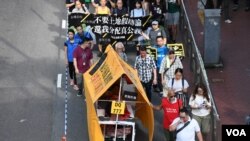 遊行人士製作”流動劏房車”反映住劏房又貴又細的苦況。(美國之音湯惠芸)