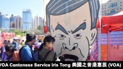 市民排隊在香港工黨的攤位玩免費遊戲，用拖鞋擲特首梁振英巨型頭像 (攝影﹕美國之音湯惠芸)