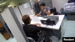 FILE - Wassana Meechamnarn, 32, a former surrogate mother, talks to a police investigator to give her testimony as a witness in a surrogacy scandal involving a Japanese businessman who have fathered 16 babies at Lumpini police station in Bangkok, Thailand, Aug. 25, 2014.