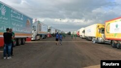 2023年10月17日，在埃及拉法，载有人道主义援助物资的卡车等待拉法过境点重新开放，以便在以色列和哈马斯之间持续不断的冲突中进入加沙。（路透社照片）
