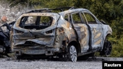 A burned car allegedly used by the perpetrators of the murder of the Russian pilot Maxim Kuzminov to escape the scene is parked outside the Spanish Civil Guard barracks, in El Campello, Spain, Feb. 14, 2024.