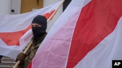 Військовослужбовець тримає білоруський прапор під час церемонії похорону Едуарда Лобова, білоруського воїна-добровольця, який загинув, захищаючи Донецьку область, 4 лютого 2023 р. Фото: AP/Efrem Lukatsky