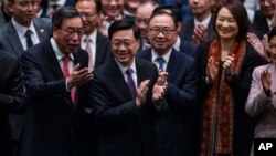 资料照片: 2024年3月19日香港立法会通过《基本法》第 23 条立法后，香港行政长官李家超鼓掌。