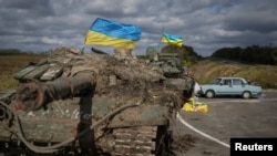 在伊久姆镇附近，一辆被缴获的俄军坦克插上了乌克兰旗帜。(2022年9月19日)