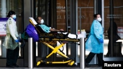 纽约大学兰贡医院的医护人员正在转移一名戴口罩的病人。（2020年5月3日）