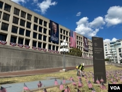 在劳工节长周末到来前，工人在位于华盛顿的美国劳工部总部大楼附近插放小美国国旗。(2025年8月28日)