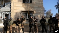 在摩苏尔东部打击伊斯兰国激进分子的战斗中，伊拉克特种部队在摩苏尔大学里走动（2017年1月14日）