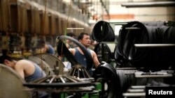 中國河北邢台萬達輪胎公司的工人正在生產出口美日的汽車輪胎生產線上工作。（2019年5月21日）
