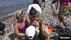 9月7日，救援人員在希臘萊斯沃斯島上救助一名暈倒的敘利亞難民。
