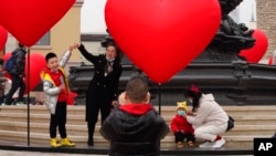 北京的一名家長和孩子一起遊玩拍照。（2021年2月13日）