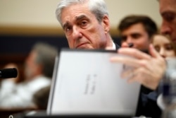 Former special counsel Robert Mueller, checks pages in the report as he testifies before the House Judiciary Committee hearing on his report on Russian election interference, on Capitol Hill, July 24, 2019 in Washington.