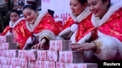 在中国杭州一个公园里，工作人员在一场有奖游戏中摆放百元钞票（2016年1月26日）