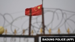 资料照：中国国旗在新疆喀什一处由铁丝网围绕的设施附近飘扬。 