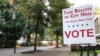 A sidewalk sign directs voters where to go in front of the library in Lake Oswego, Ore., Oct. 31, 2018.