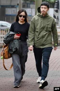 被裁定暴動罪成的被告之一，香港藝人王宗堯在判決前與女友進入法院。（法新社照片）