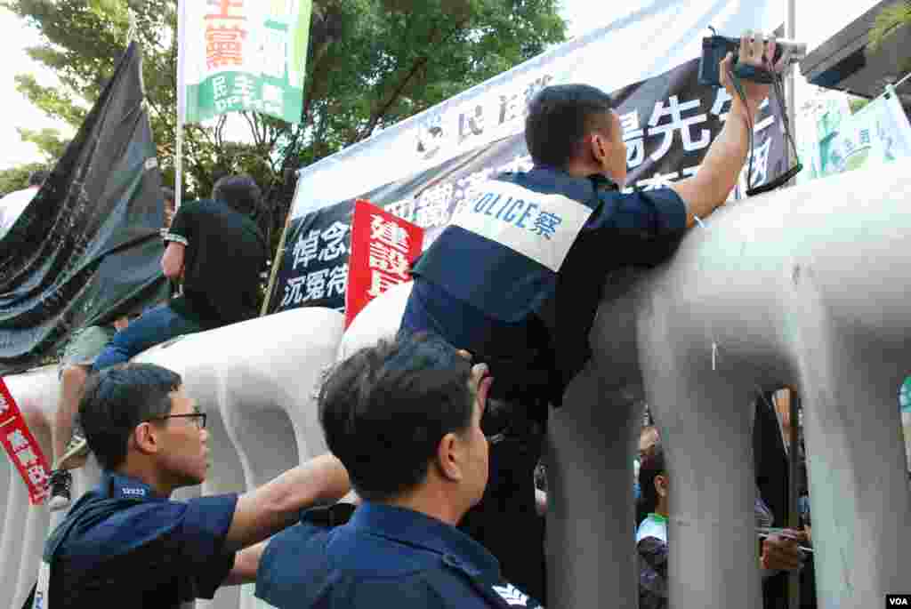 有警員爬上水馬陣拍攝示威區內及附近的情況