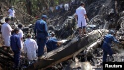 老撾的救援人員在飛機墜毀現場進行搜救工作。
