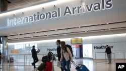 资料照片：伦敦希思罗机场中戴口罩的乘客（2020年6月8号）。