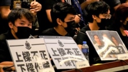 多名元朗民主派區議員在座位前放上抗議警方的標語。(美國之音湯惠芸)