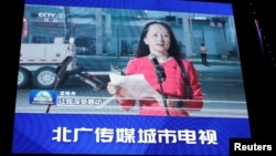 北京一家商場外的巨型電子屏幕正在播放華為高管孟晚舟從加拿大抵達深圳的報導。（2021年9月26日）