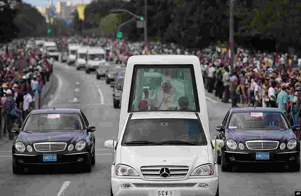 Pope Benedict waves to people from his popemobile as he departs for the airport in Havana, March 28, 2012. (AP)