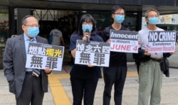 支联会副主席何俊仁（左起）及邹幸彤与两名成员到区域法院大楼外声援黄之锋等被告，他们高呼悼念六四无罪等口号 (美国之音/汤惠芸)