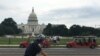 Tourists stand in front of the U.S. Capitol in Washington, DC, on an unusually warm day, with highs into the upper 80s fahrenheit in some areas, Thursday, July 18, 2019. (Photo by Diaa Bekheet)