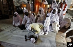 来自尼日利亚的基督徒朝圣者在伯利恒的圣诞洞祷告。(2012年12月24日)
