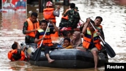 Rescuers evacuate people using a rubber boat from a flooded residential area following heavy rains in Jakarta, Indonesia, March 4, 2025. 