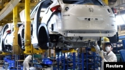 中國湖北武漢的東風集團本田汽車公司的工人在生產線上工作。 （2020年3月16日）