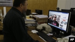 A gondola used to transport people to the biathlon and cross country skiing venues is silhouetted against the rising moon in Krasnaya Polyana, Russia.