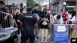 在北京的一條旅遊購物街，人們用智能手機向保安出示健康碼（2021年8月3日）。