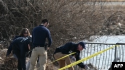 .ບັນດາ​ເຈົ້າ​ໜ້າ​ທີ່​ສືບ​ສວນ​ເກັບ​ກຳ​ຊິ້ນ​ສ່ວນ​ຂອງ​ຊາກ​ຫັກ​ພັງ​ຢູ່​ຕາມ​ແມ່​ນ້ຳ Potomac ທີ່ເປັນເຂດຊາຍແດນລະຫວ່າງ ນະຄອນຫຼວງ ວໍຊິງຕັນ ແລະເມືອງອາຣລິງຕັນ ຂອງລັດເວີຈີເນຍ. (Photo by ANDREW CABALLERO-REYNOLDS / AFP)