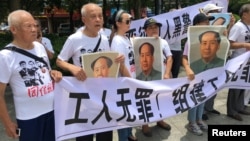 人們在中國廣東省深圳市坪山區燕子嶺派出所外示威，手持標語，支持佳士工廠工人組建工會要求。（2018年8月6日）