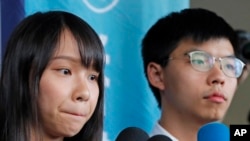 前“香港眾志”的秘書長黃之鋒及成員周庭（左）在一家地區法院前對媒體講話。 （2019年8月30日）