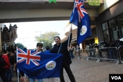 香港市民曾先生(右)與幾名示威者高舉殖民時期的港英旗幟，到上水火車站反水貨客