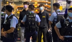 賢學思政召集人王逸戰（藍色口罩者）等4名成員以及3名市民共7人，被警察截查後被拘捕，12月1日凌晨全部獲准保釋。(美國之音特約記者湯惠芸攝)