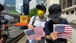 兩名香港市民7月4日美國獨立日手持A4紙印的美國國旗到美國領事館附近慶祝。(美國之音 湯惠芸拍攝)