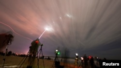 Люди наблюдают, как ракета Blue Origin New Glenn совершает свой первый запуск на мысе Канаверал, штат Флорида, США, 16 января 2025 года